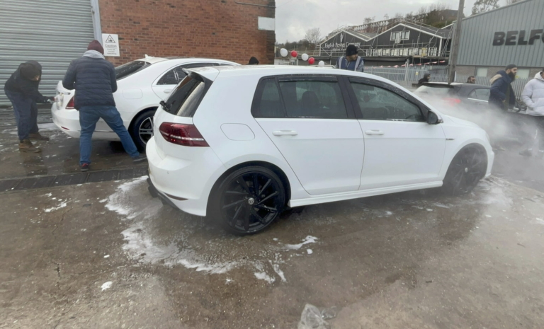 A white Volkswagen being washed as part of a charity car wash event